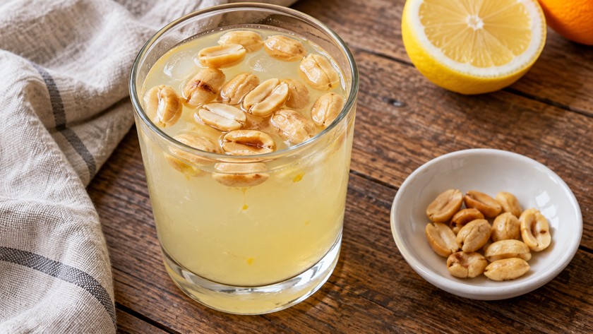 Bardaktaki narenciye limonatasına eklenen soyulmuş yer fıstıkları; temsili görsel